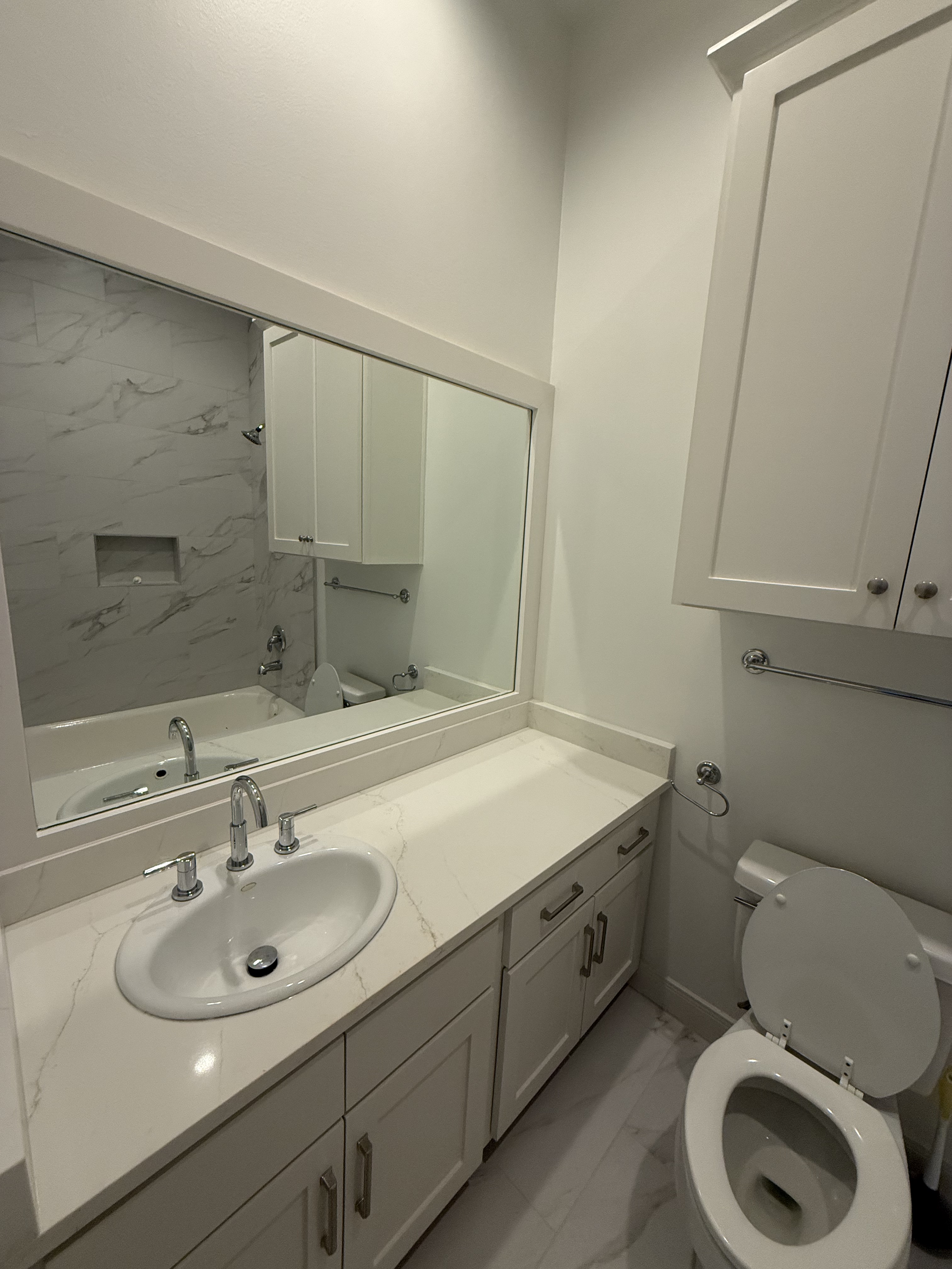 Bathroom remodel with quartz vanity and framed mirror