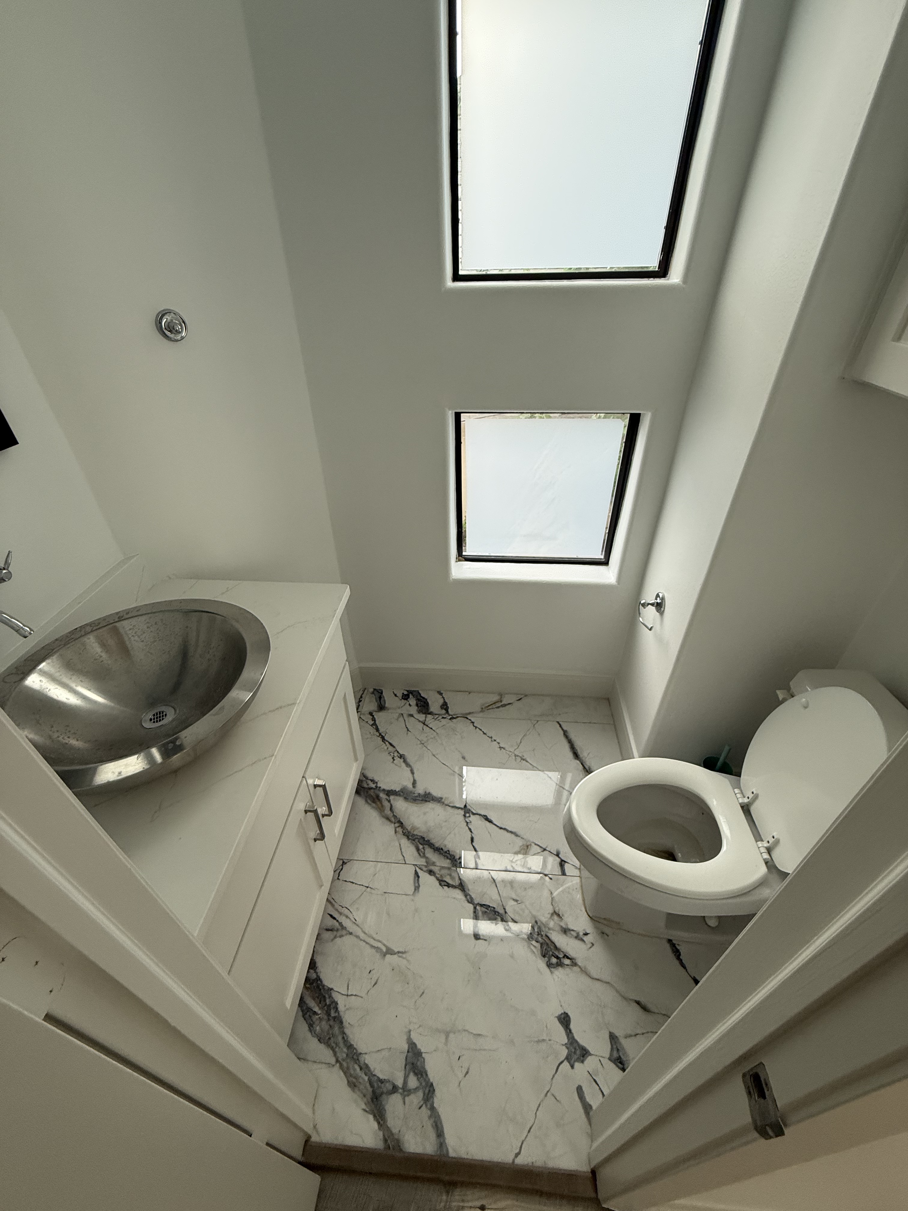 Powder bath with marble-look tile floor and vessel sink