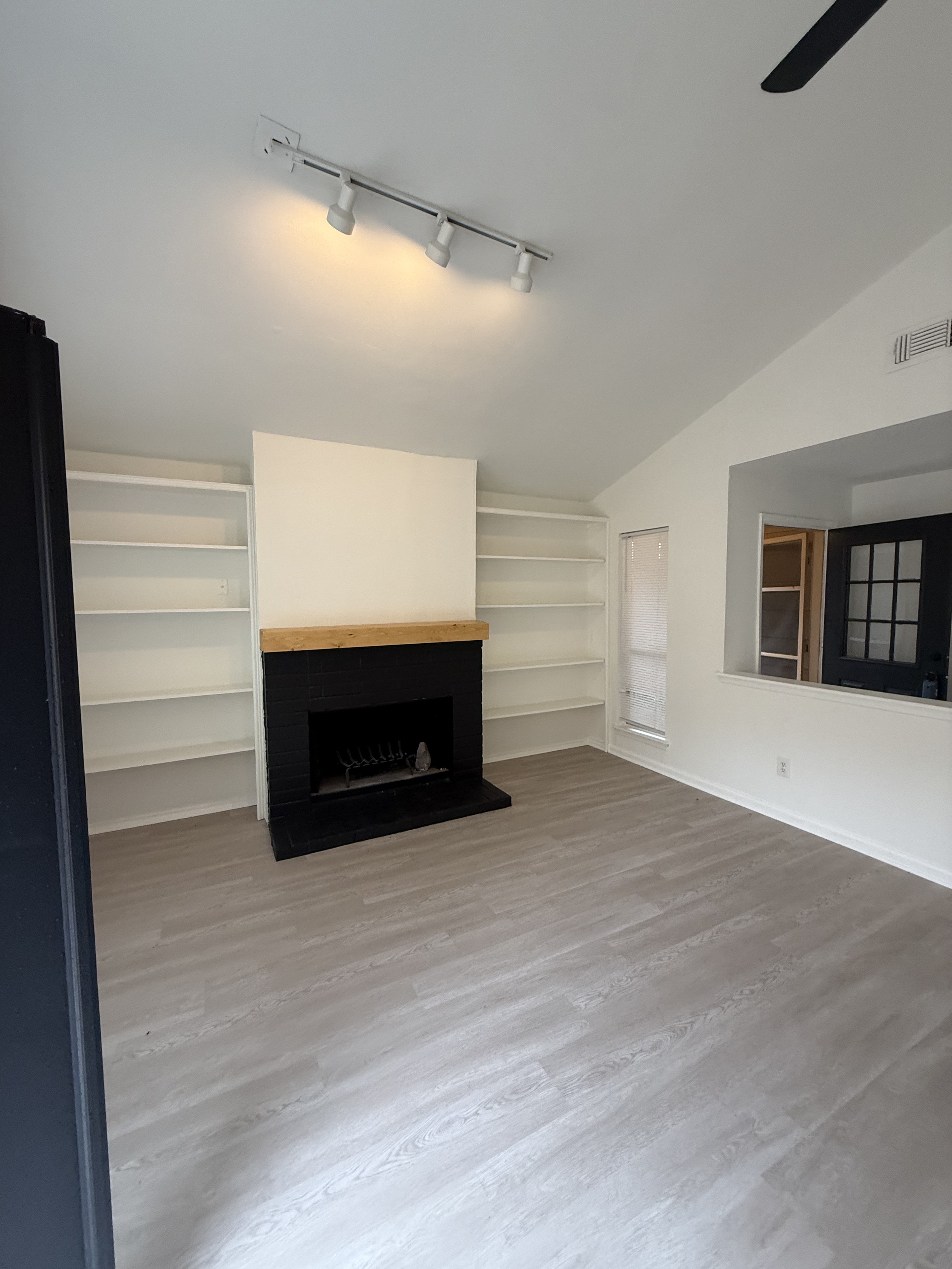 Living room remodel with black brick fireplace and built-in shelving